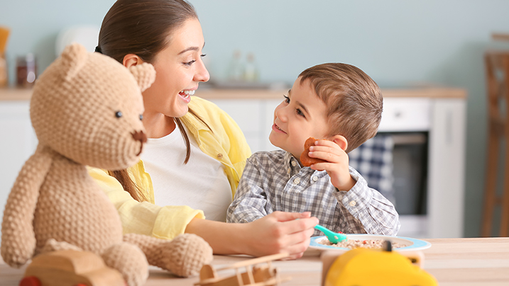 Nanny,Feeding,Cute,Little,Boy,In,Kitchen